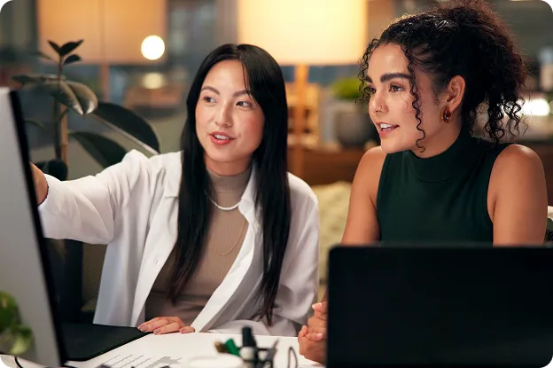 Two diverse women collaborating in a modern office space.