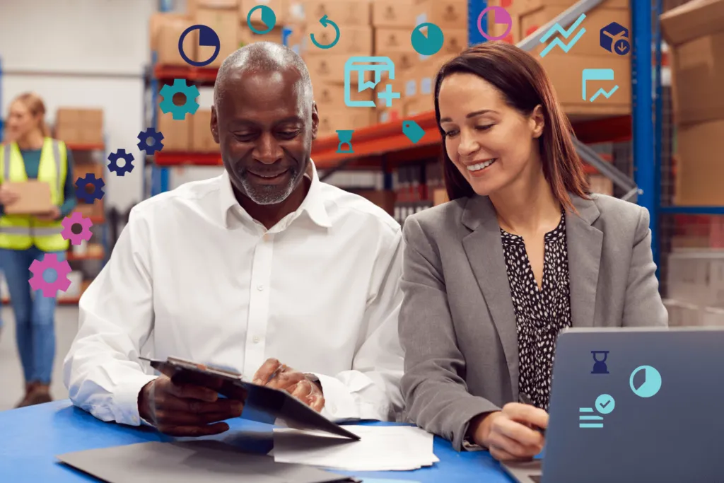 Two smiling professionals collaborating in a warehouse, using digital devices surrounded by floating icons representing various business analytics and inventory management tools.