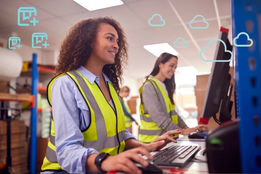 Warehouse workers using computers with cloud computing icons, showcasing modern inventory management and data processing in a distribution centre.
